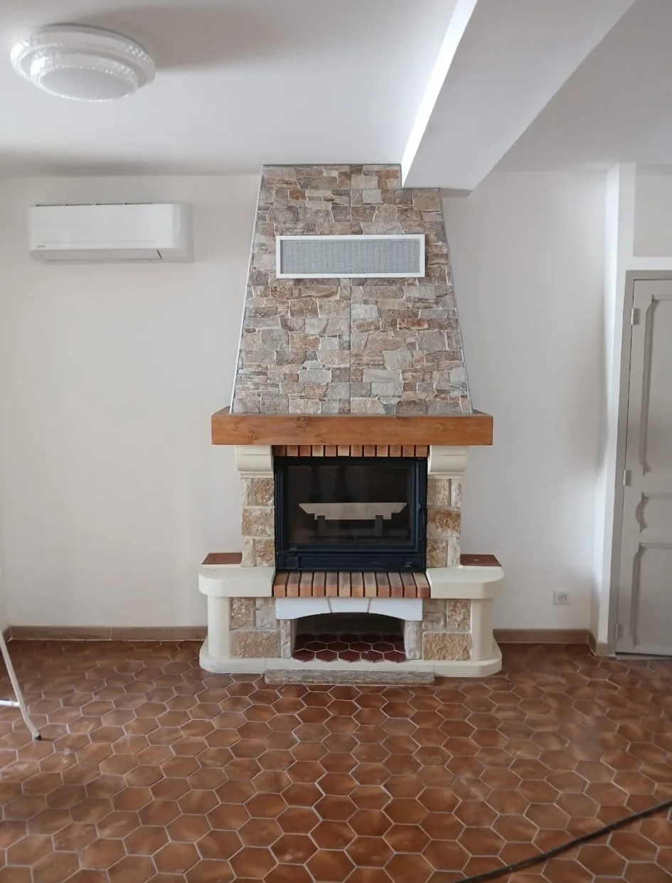 Habillage cheminée en parement pierre naturelle et linteau bois à Ajaccio