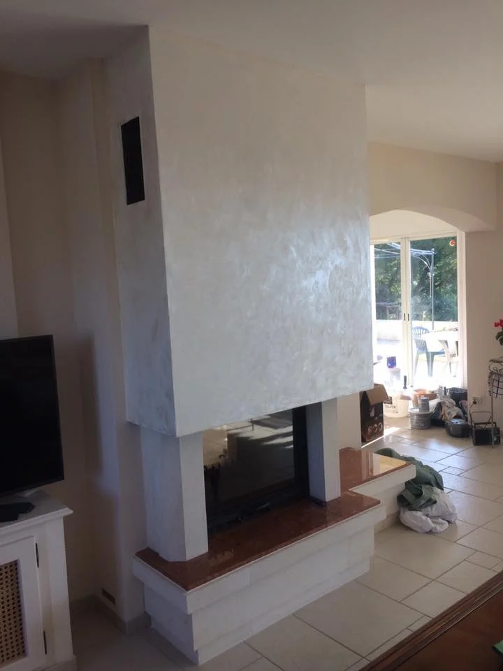 Cheminée moderne avec enduit décoratif texturé et plateau en marbre.