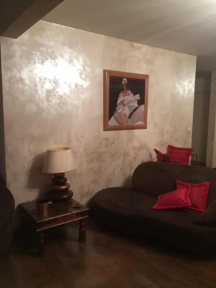 Mur de salon avec enduit décoratif lumineux effet stuc.